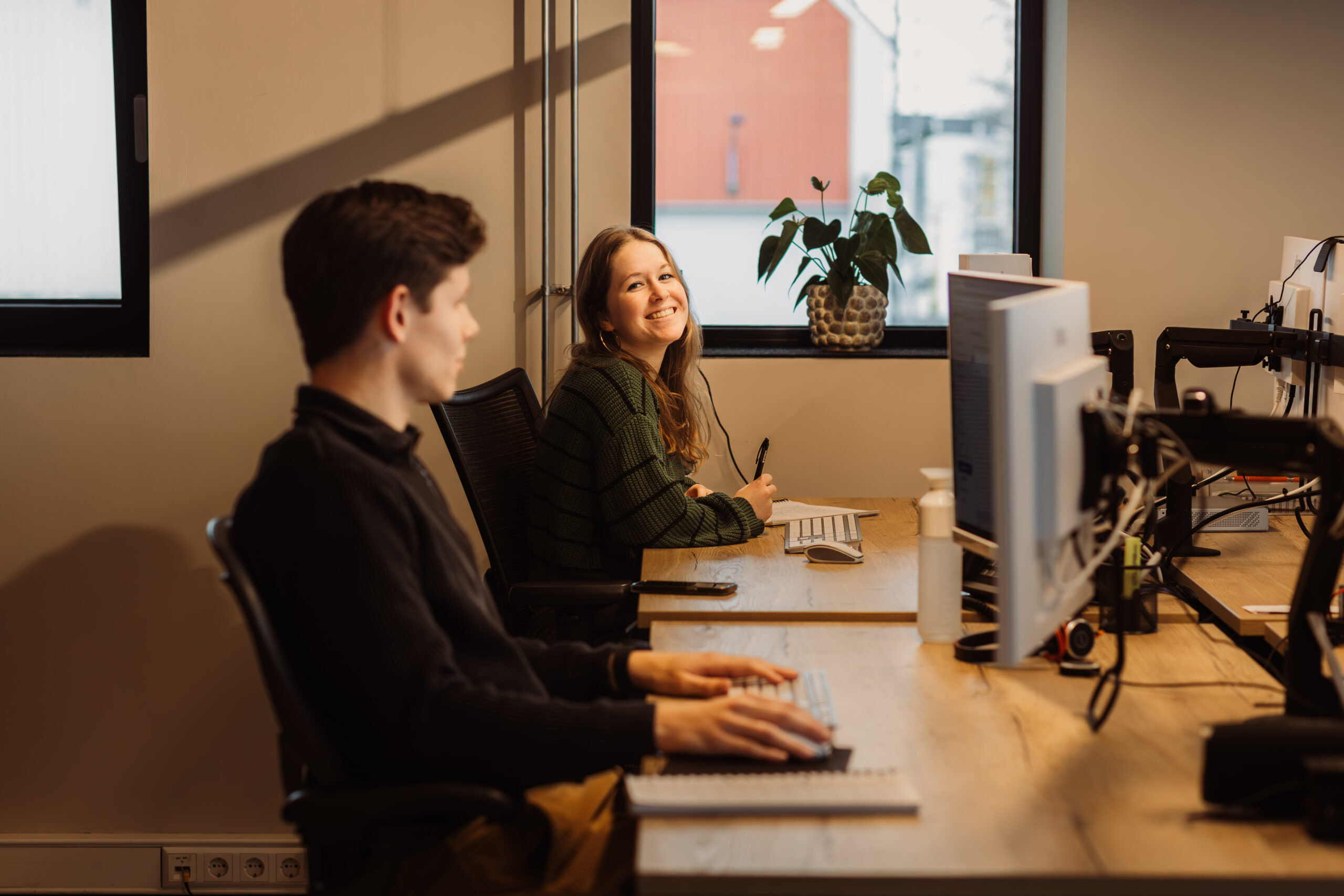 Thirza en Tom lachend aan het werk aan online resultaten.