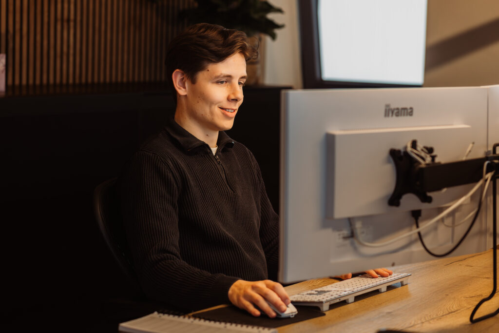 Tom online marketing speciliast werkt aan camapagnes achter pc.