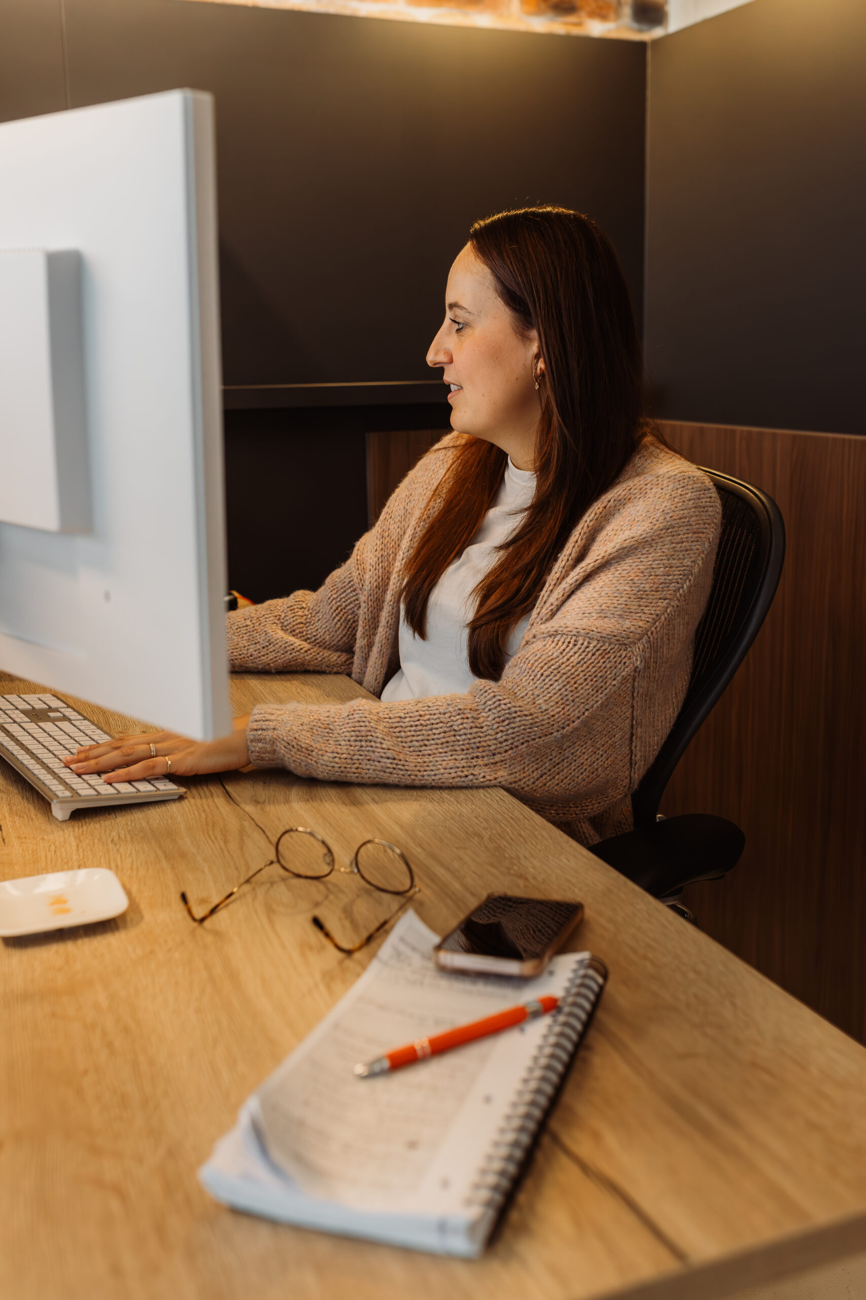 Karin online marketing specialist werkt geconcentreerd aan campagnes achter haar pc.