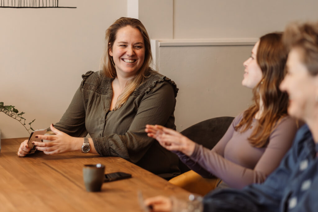 Chelsey online marketing specialist lachend met collega's.