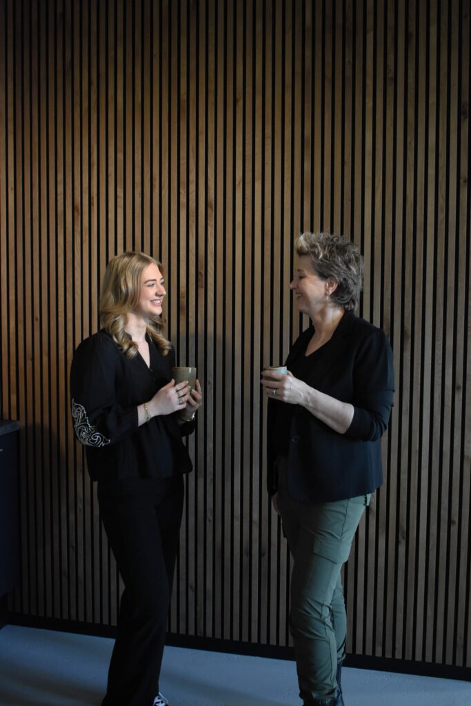 Foto van Shannon en Astrid voor houte muur.